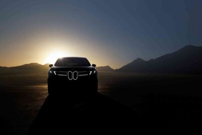 BMW-iX3-auf-Straße-Frontansicht-bei-Sonnenuntergang